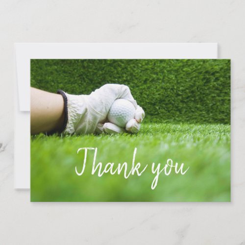 Golfer is holding golf ball on green grass thank you card
