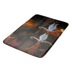 Graceful White Swans Gliding Across Autumn Pond Bath Mat