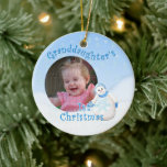 Grandaughter's 1st Christmas Snowman Round Photo Ceramic Ornament<br><div class="desc">Your granddaughter will cherish her 1st christmas snowman ornament with her photo. This adorable showgirl is decked out in fuzzy blue hat, scarf and mittens as delicate snowflakes fall through the winter sky. Add photo to front and name and year to the back of the ornament using the template provided....</div>