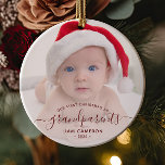 Grandparents First Christmas Photo Red Script Ceramic Ornament<br><div class="desc">Help them celebrate their first grandchild with this beautiful modern keepsake ornament. The burgundy red text reads "Our first Christmas as grandparents, " with the word "grandparents" in elegant handwriting script with flourishes before and after. Easily replace the sample image with your favorite photo of the new baby, and add...</div>