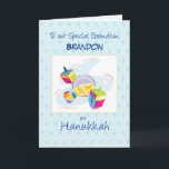 Grandson Hanukkah Customizable Name Blue  Card<br><div class="desc">Send this delightful card to your grandson on Hanukkah. Light blue background has darker blue dots. A dreidel with toys and gifts is at the center of this Jewish holiday card. Personalize the card with his name on the front.</div>