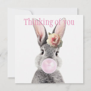 Gray rabbit blowing bubble gum with anemone flower