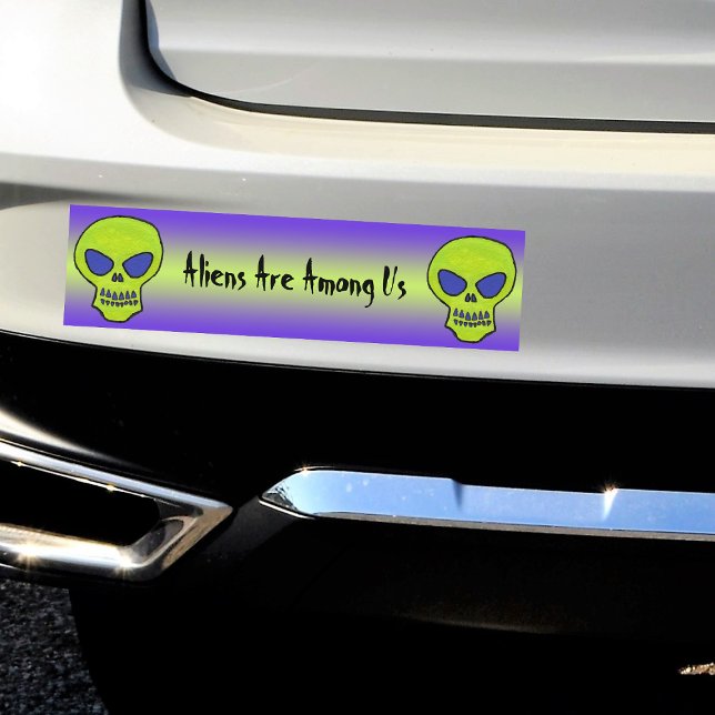 Green Alien Skull Bumper Sticker (Two Neon green alien skulls on green and purple Aliens Are Among Us bumper sticker for your car.)
