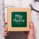 Green and White Brush Script Merry Christmas Square Sticker<br><div class="desc">Modern holiday stickers featuring "Merry Christmas" displayed in white brush script lettering with a green background. Personalize the simple Merry Christmas stickers with your name and year in white lettering. The green Christmas stickers are perfect for sealing holiday envelopes,  party favor bags,  and gifts.</div>