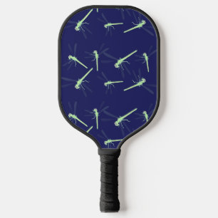 Green dragonflies on blue pickleball paddle