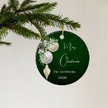 Green gold white baubles Christmas Ceramic Ornament<br><div class="desc">A rustic green uneven colored background. Decorated with white and gold baubles and some greenery and a pine cone.  Personalize and add your name,  year.  Text: Merry Christmas</div>