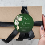 Green gold white baubles Christmas Classic Round Sticker<br><div class="desc">For a Christmas party favors or gift wrapping. A rustic green uneven colored background. Decorated with white and gold baubles and some greenery and a pine cone.  Personalize and add your name,  year.  Text: Merry Christmas</div>