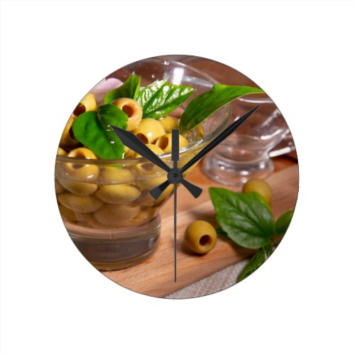 Green pitted olives in a glass cup round clock