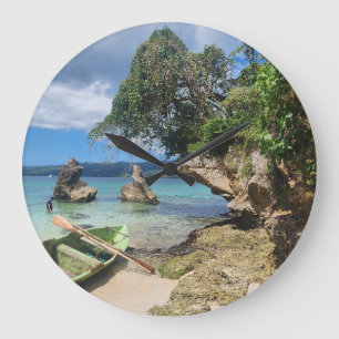 Green wooden fishing boat on a white sand large clock