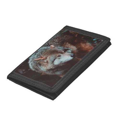 Grey Wolf looking in the forest Trifold Wallet