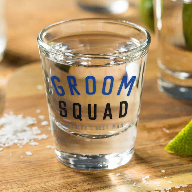 Groom squad shot glass with blue and black lettering.
