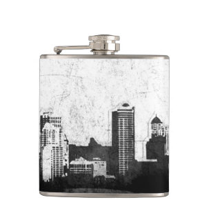 Grungy city background in black and white hip flask