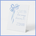 Guess How Many Kisses Blue Bow Bridal Shower Pedestal Sign<br><div class="desc">Designed for hosts who appreciate refined details, this Guess How Many Kisses game sign is a stunning way to invite guests to participate in a sweet and stylish challenge. With its elegant blue ribbon illustration and graceful typography, this piece sets the tone for a polished and thoughtfully curated bridal shower...</div>