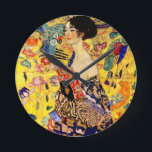 Gustav Klimt Lady with Fan Round Clock<br><div class="desc">Clock featuring Gustav Klimt’s oil painting Lady with Fan (1918). A woman wearing a blue kimono holds a red fan against a colorful yellow background of flowers and peacocks. A great gift for fans of Japonisme and European art.</div>