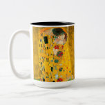 Gustav Klimt The Kiss Two-Tone Coffee Mug<br><div class="desc">Coffee Mug featuring Gustav Klimt’s oil painting with gold leaf The Kiss (1908). A man and woman,  wearing brilliant golden colors,  lovingly embrace and kiss in a field of flowers. A great gift for fans of Art Nouveau and Austrian art.</div>