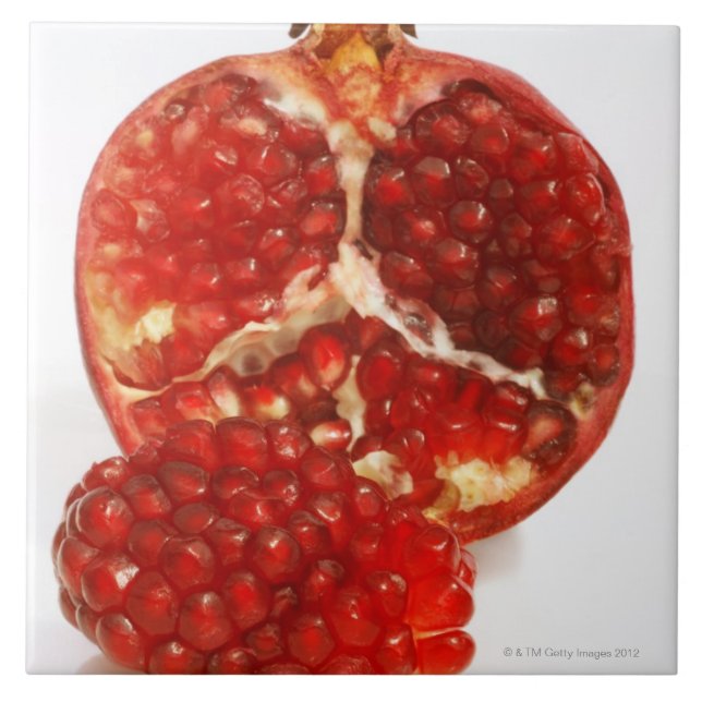 Half a ripe pomegranate cut to expose the juicy tile (Front)