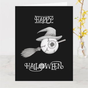 Halloween witch broom and scary eyeball card
