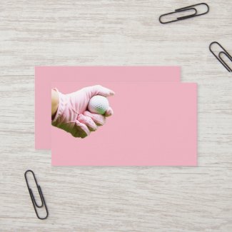 Hand in pink glove is holding golf ball business card