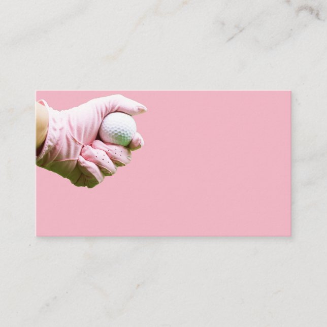 Hand in pink glove is holding golf ball business card (Front)
