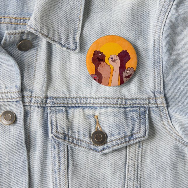 Hands with fist raised up over yellow sun  button (In Situ)