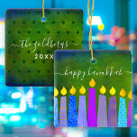 Hanukkah Menorah Candle Script Name Green Keepsake Ceramic Ornament<br><div class="desc">“Happy Hanukkah.” A playful, modern, artsy illustration of boho pattern candles helps you usher in the holiday of Hanukkah in style. Assorted blue candles with colorful faux foil patterns overlay a rich, deep green textured background. On the back, personalize with your family name and year, over a tiny dark green...</div>