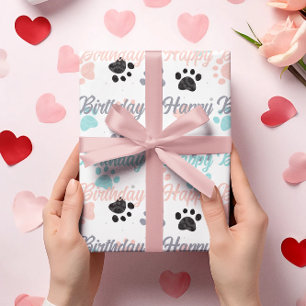Happy birthday text, dog paw prints pattern wrapping paper