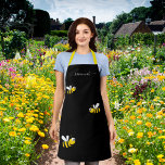 Happy bumble bees yellow black monogram chic apron<br><div class="desc">A stylish balck background. Decorated with happy,  smiling bumble bees. Personalize and add your name,  written with a trendy white hand lettered style script with swashes. To keep the swashes only delete the sample name,  leave the spaces or emoji's in front and after the name.</div>
