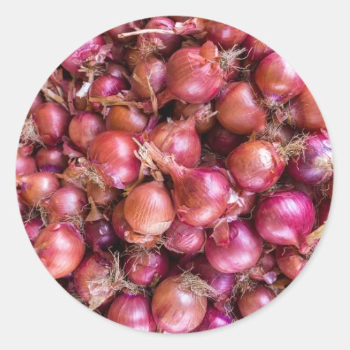 Heap of red onions on market classic round sticker