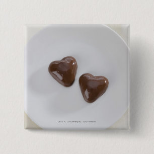 Heart shaped chocolate candies on a plate pinback button