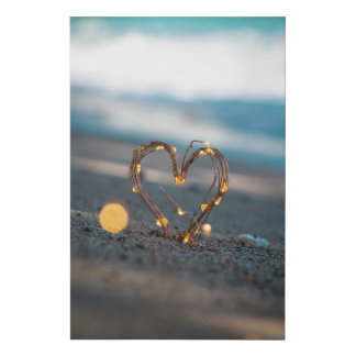 Heart-shaped lights in sand on a beach faux canvas print
