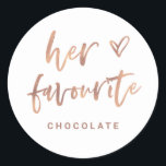 Her Favourite | Casual Rose Gold Script and Heart Classic Round Sticker<br><div class="desc">This simple and stylish favor label is perfect for your modern wedding! Trendy, faux rose gold and white casual handwritten script says "her favourite", using British / Canadian / Australian spelling. There is also an elegant sketched heart and a spot to add the favourite type of treat of the bride....</div>