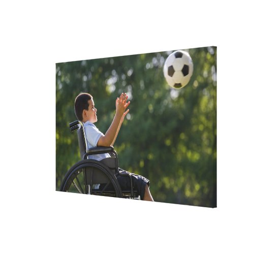 Hispanic boy 8 in wheelchair with soccer ball canvas print