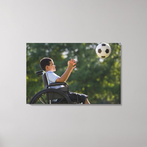 Hispanic boy 8 in wheelchair with soccer ball canvas print