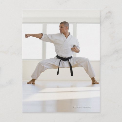 Hispanic male karate black belt in fighting postcard