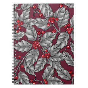 Holly berry, gray leaves on dark red notebook