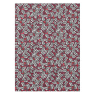 Holly berry, gray leaves on dark red tablecloth