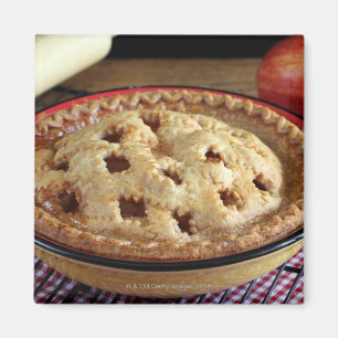 Home baked apple pie on cooling rack with apple magnet