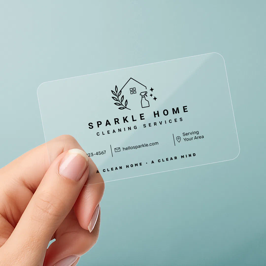 Transparent business card with black text and emoji like icons of a leaf branch, spray bottle and a house with a window. There's a manicured hand holding it with a blue overall background.
