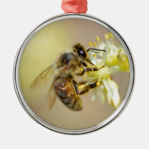 Honey bee feeding on flower metal ornament