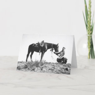 Horse eating from a cowboy's hat. card