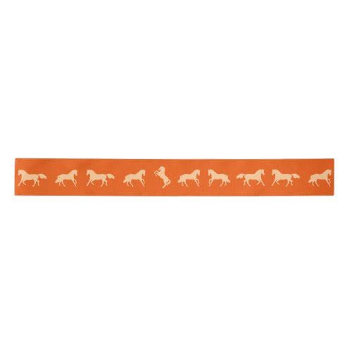 Horses in gold on red satin ribbon