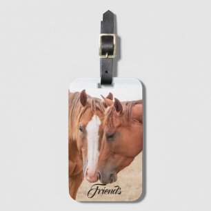 Horses nuzzling in a pasture luggage tag