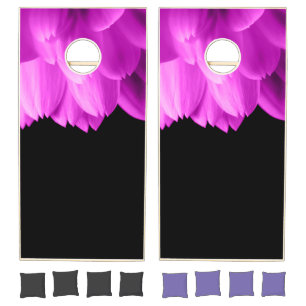 Hot pink flower petals on black cornhole set