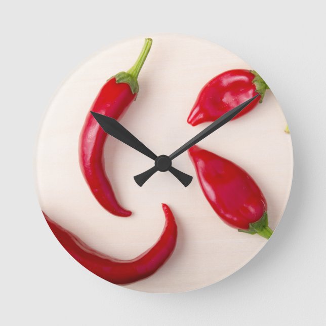 Hot red chili peppers on a light wooden board round clock (Front)