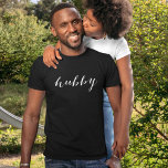 Hubby Modern White Script Black Mens T-Shirt<br><div class="desc">Bold and timeless, this black tee showcases "Hubby" in flowing modern white script for a sharp newlywed look. Perfect for honeymoon travel, anniversary celebrations, or everyday husband pride. The elegant hand-lettered calligraphy stands out against the black backdrop, making it an eye-catching gift for the groom or new husband. Coordinates beautifully...</div>