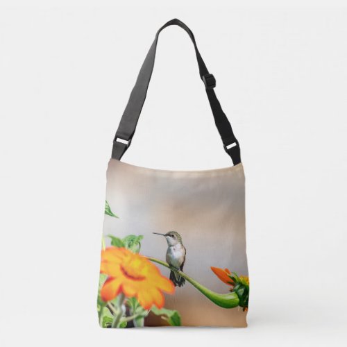 Hummingbird on a flowering plant crossbody bag