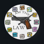 I Am the Law Gun  Round Clock<br><div class="desc">This bold and striking clock design features a powerful handgun integrated into the clock hands, making a strong statement about authority and justice. The words “I AM THE LAW” stand prominently against a clean white background, surrounded by colorful Roman numerals that add a unique artistic contrast. Perfect for those who...</div>