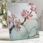Japanese Watercolor Cherry Blossom Kintsugi Ceramic Tile<br><div class="desc">Elevate your space with this Japanese-inspired tile featuring delicate cherry blossom branches in soft pink watercolor on a serene light blue background. The design is enhanced with gold Kintsugi-style cracks, symbolizing the art of finding beauty in imperfection. Perfect for creating tranquil backsplashes, accent walls, or decorative projects, this tile’s organic...</div>
