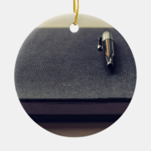 Journal Themed, A Fountain Pen Rests On A Black Bo Ceramic Ornament