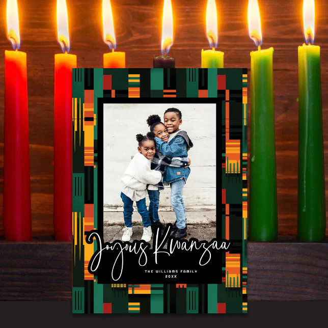 A Kwanzaa-themed card covered in black, orange, yellow, and green elements with seven candles in the background.